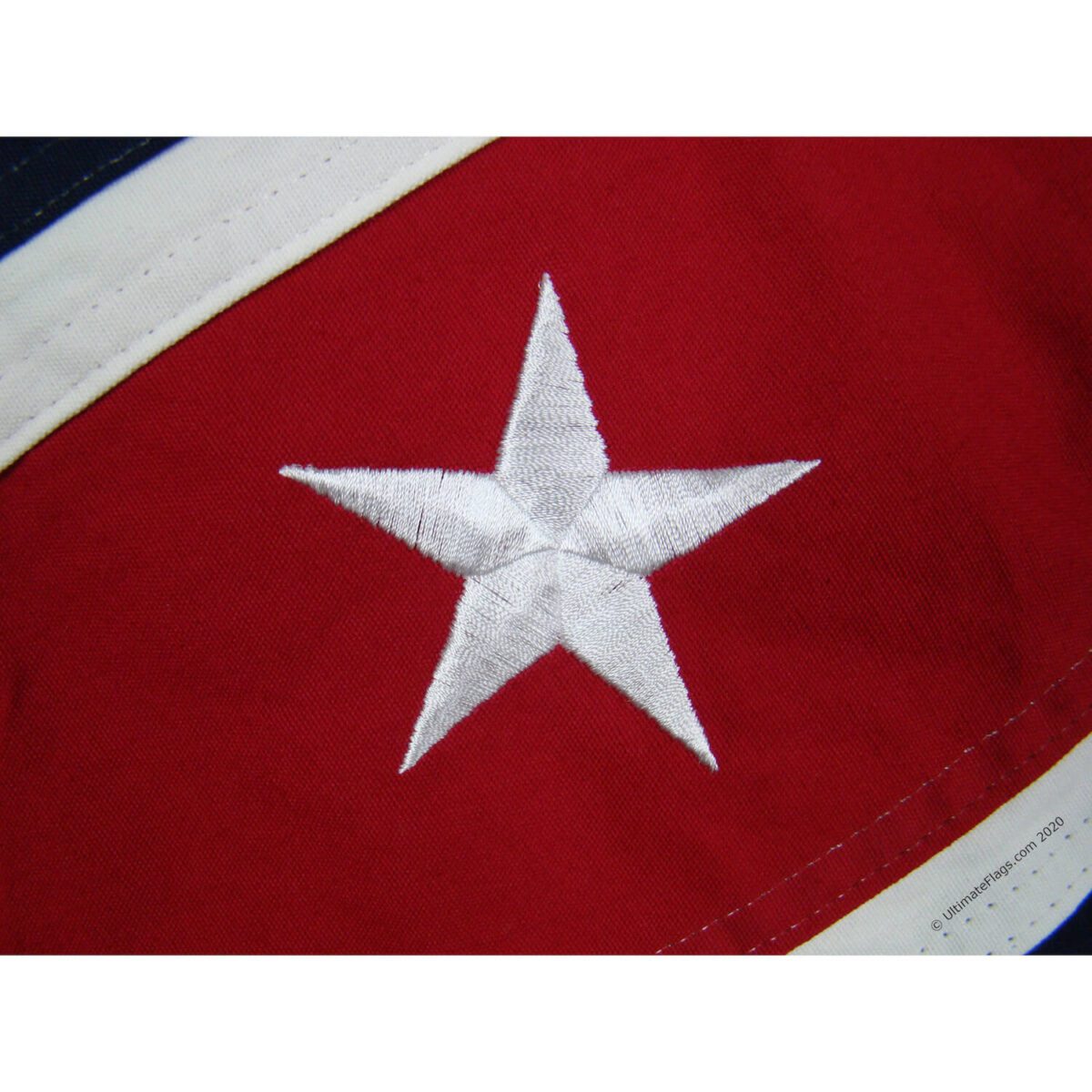 This close-up image showcases a beautifully embroidered white star on a red background, perfect for patriotic displays. Ideal for those looking to buy online affordable flags, this product stands out as the best choice for quality and design. Find your perfect flag at UltimateFlags.com.