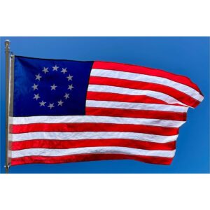 American flag waving against a blue sky, featuring the Betsy Ross design with 13 stripes and a circle of stars, symbolizing patriotism and history. This affordable flag is perfect for those looking to buy online at the best prices. Visit UltimateFlags.com for more great deals.