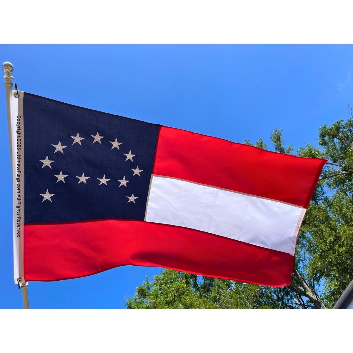 Georgia state flag waving against a clear blue sky, showcasing its vibrant colors and design. Find the best affordable flags to buy online, including this Georgia flag, at UltimateFlags.com.