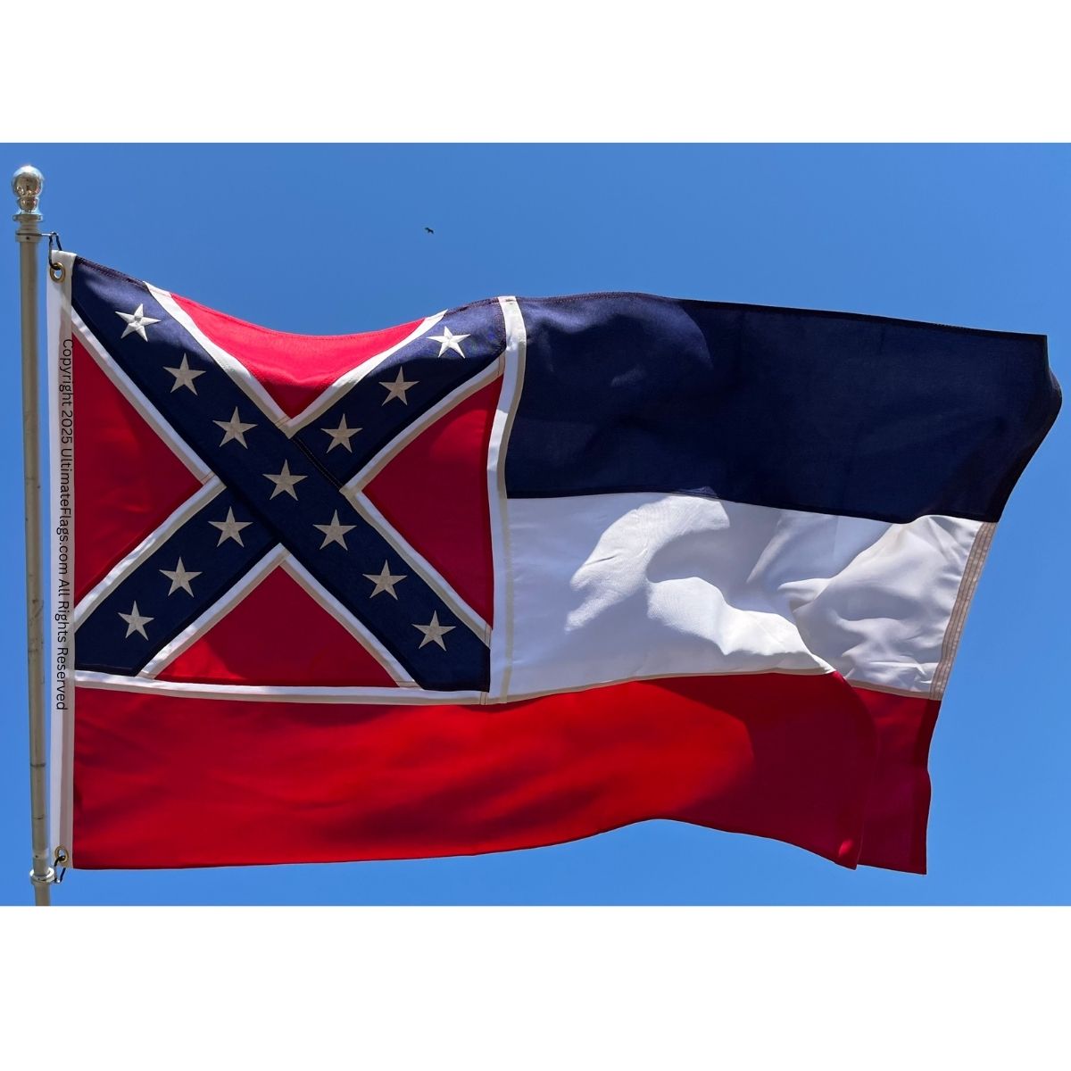 Mississippi state flag waving against a clear blue sky, showcasing its vibrant colors and distinct design. This flag is available for purchase online at affordable prices, making it one of the best options for flag enthusiasts. Buy online at UltimateFlags.com for great deals on flags.