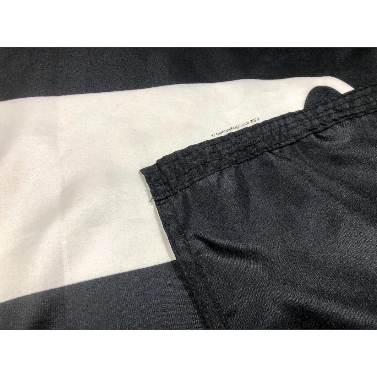 High-quality close-up of a flag's stitching and fabric, showcasing durability and attention to detail. Find the best affordable flags to buy online at UltimateFlags.com.