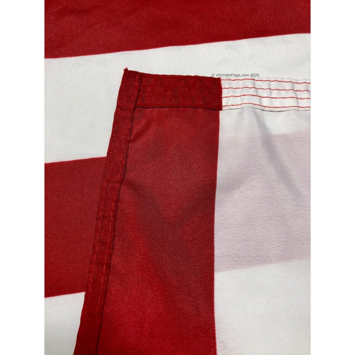 Close-up of a red and white striped flag showcasing quality stitching and vibrant colors, perfect for patriotic displays. Find cheap and affordable flags that stand out, ideal for any occasion. Buy online for the best selection at UltimateFlags.com.