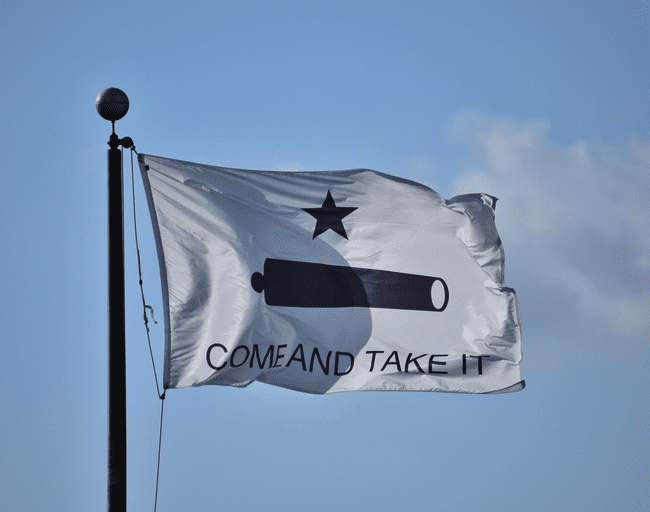 A flag displaying the phrase "Come and Take It" featuring a cannon and a star, symbolizing defiance and independence. This affordable and iconic design is perfect for those seeking the best flags to showcase their values. Buy online at UltimateFlags.com for great deals.