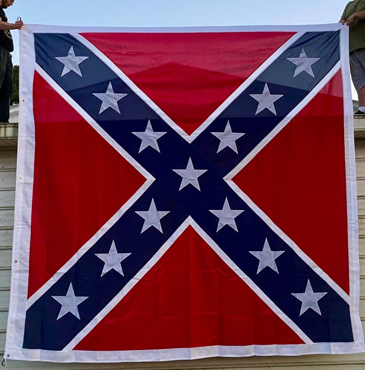 Confederate flag being held up, showcasing its vibrant red and blue colors with white stars, perfect for display or decoration. Buy this affordable and stylish flag online at UltimateFlags.com for the best deals.