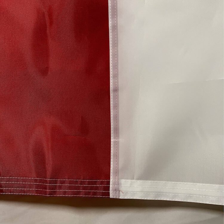 This image showcases a close-up of a high-quality flag featuring vibrant red and white colors, ideal for various occasions. Discover cheap and affordable options for flags that stand out. Buy online to find the best selection at UltimateFlags.com.