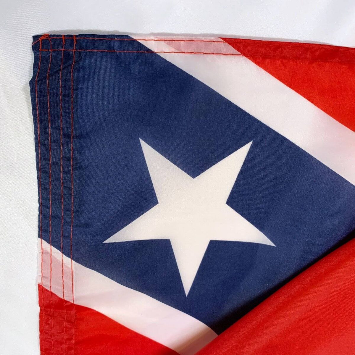 This image features a close-up of a flag with a prominent star design, showcasing vibrant red and blue colors. Discover cheap and affordable options for this flag among the best selections available to buy online. For more options, visit UltimateFlags.com.