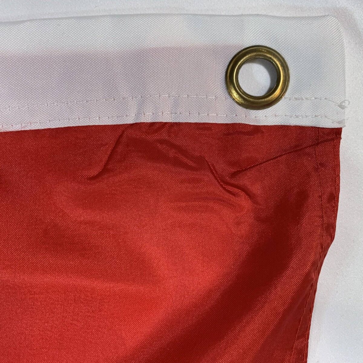 Close-up of a flag showcasing its grommet and stitching details, perfect for those seeking cheap and affordable flags that are durable and easy to display. Buy online for the best selection at UltimateFlags.com.