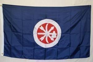 This image features a vibrant flag with a blue background and a central emblem in red and white, representing a unique design. Ideal for collectors or decorative purposes, this flag is an affordable option for anyone looking to buy online. Discover the best selection at UltimateFlags.com.