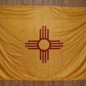 New Mexico state flag displayed on a wooden background, showcasing its vibrant yellow color and distinctive red Zia sun symbol. Perfect for those looking to buy affordable and high-quality flags online. Find the best deals at UltimateFlags.com.