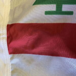 This close-up image showcases a flag featuring a prominent green design and a bold red stripe, representing a unique cultural symbol. Perfect for those looking to buy online affordable flags, this item is a great choice for anyone seeking the best deals. Shop now at UltimateFlags.com for cheap and high-quality options.